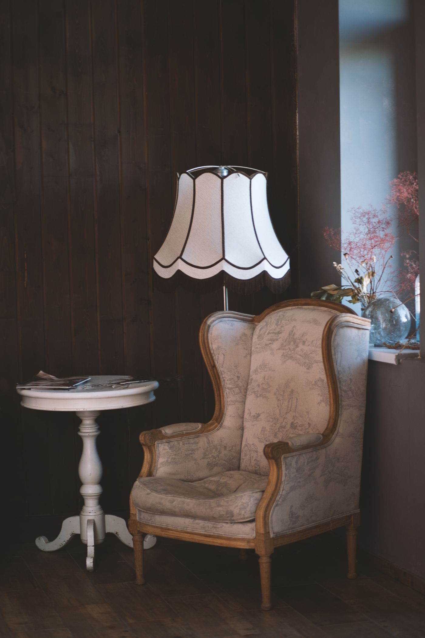 A vintage lamp and armchair styled with decor objects
