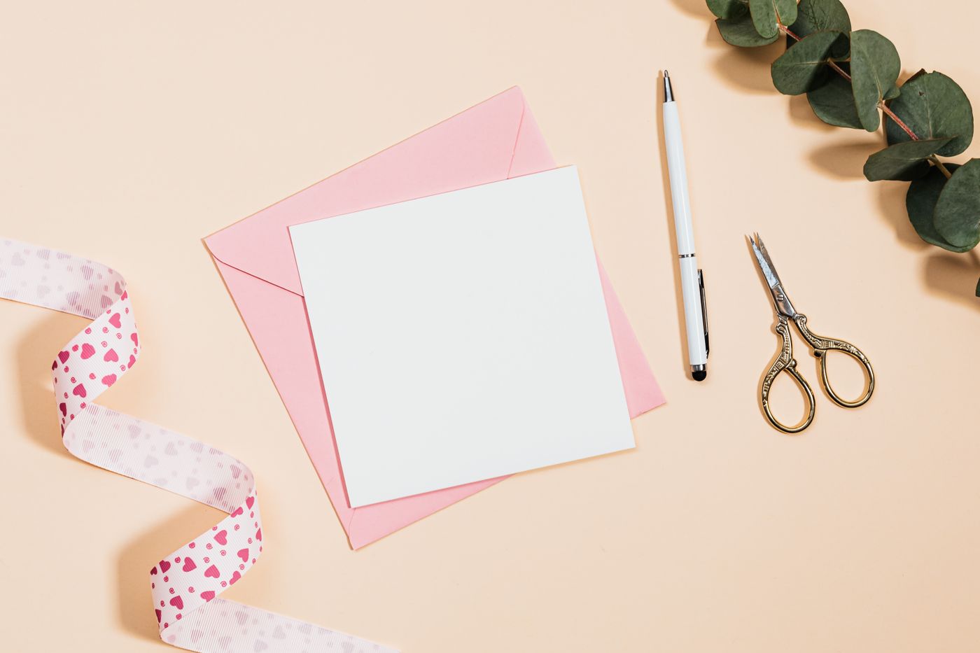 A greeting card with envelope and gilt scissors flatlay