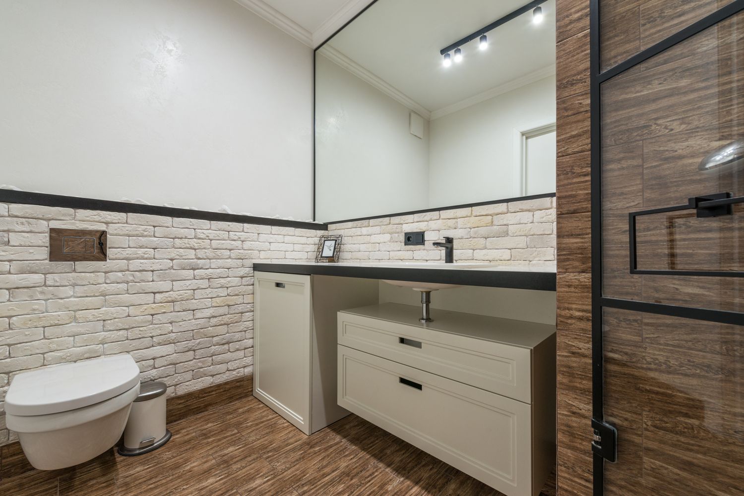 A renovated walk-in shower with large-format tile and glass