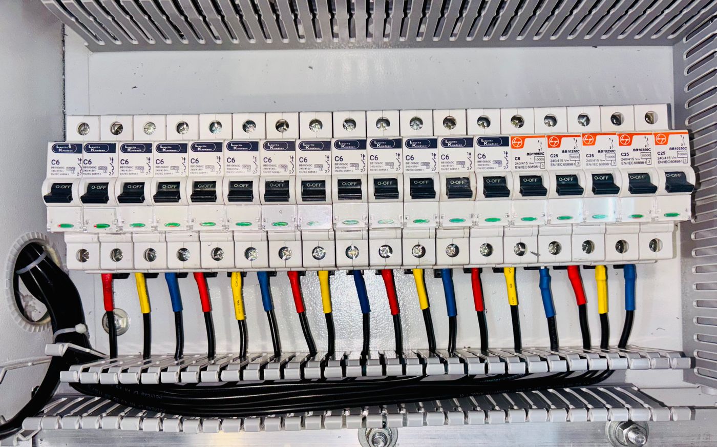 A neatly wired breaker panel with colour-coded conductors