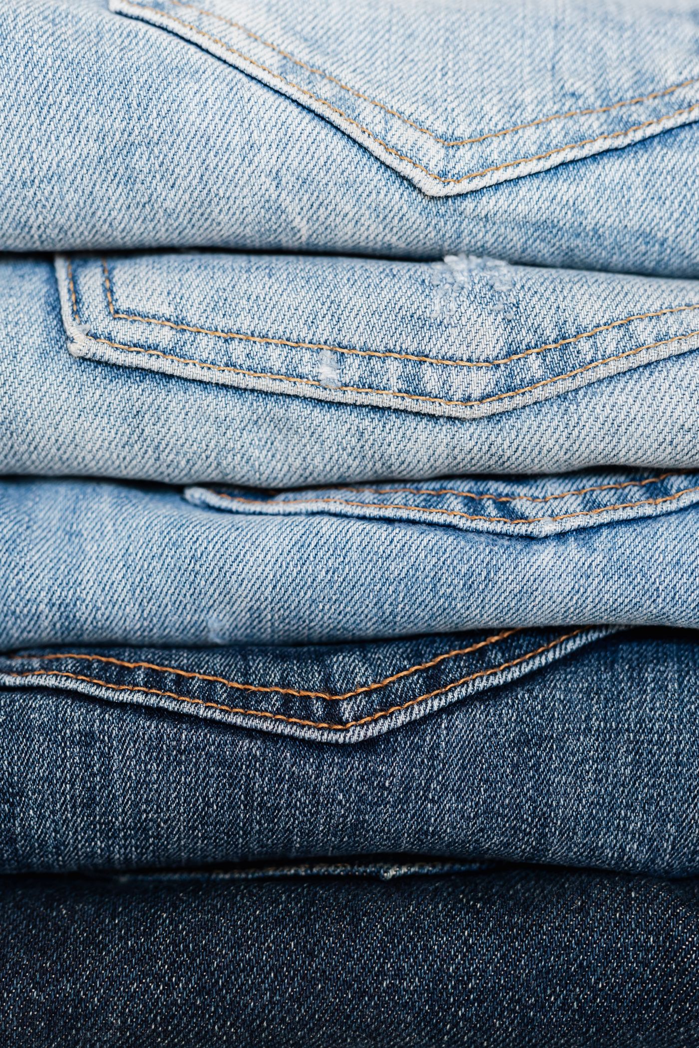 A close-up stack of folded denim showing weave and selvedge detail