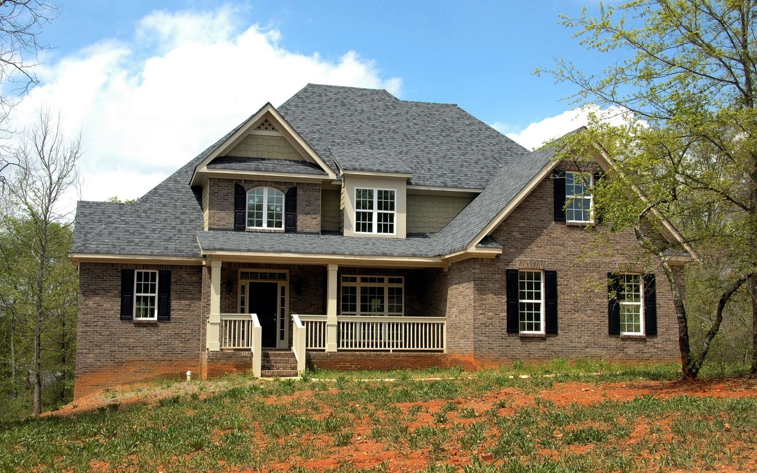 Brick home with a finished roof against the sky