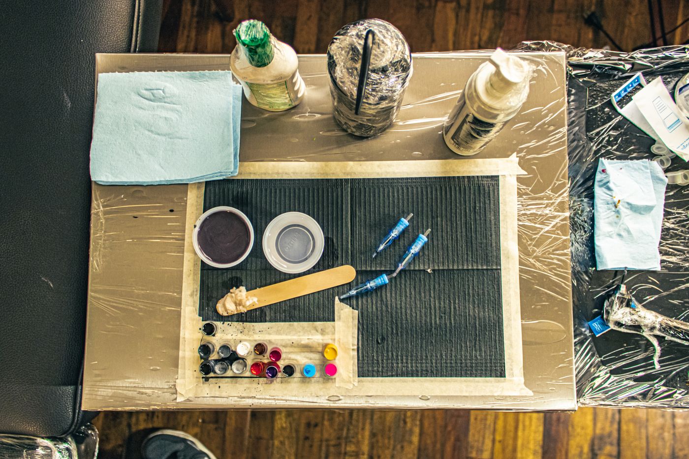 Overhead view of the tattoo workstation with ink and tools laid out