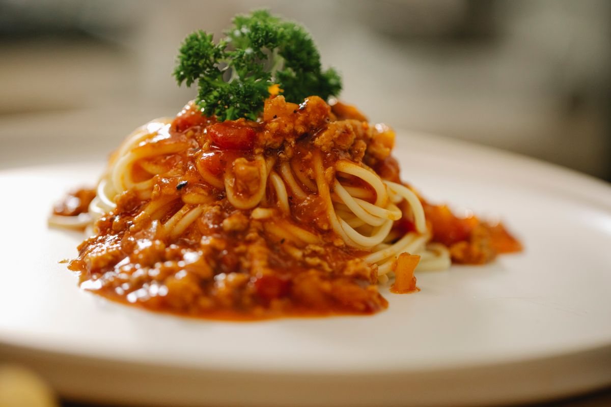 A plate of spaghetti in tomato sauce with parsley