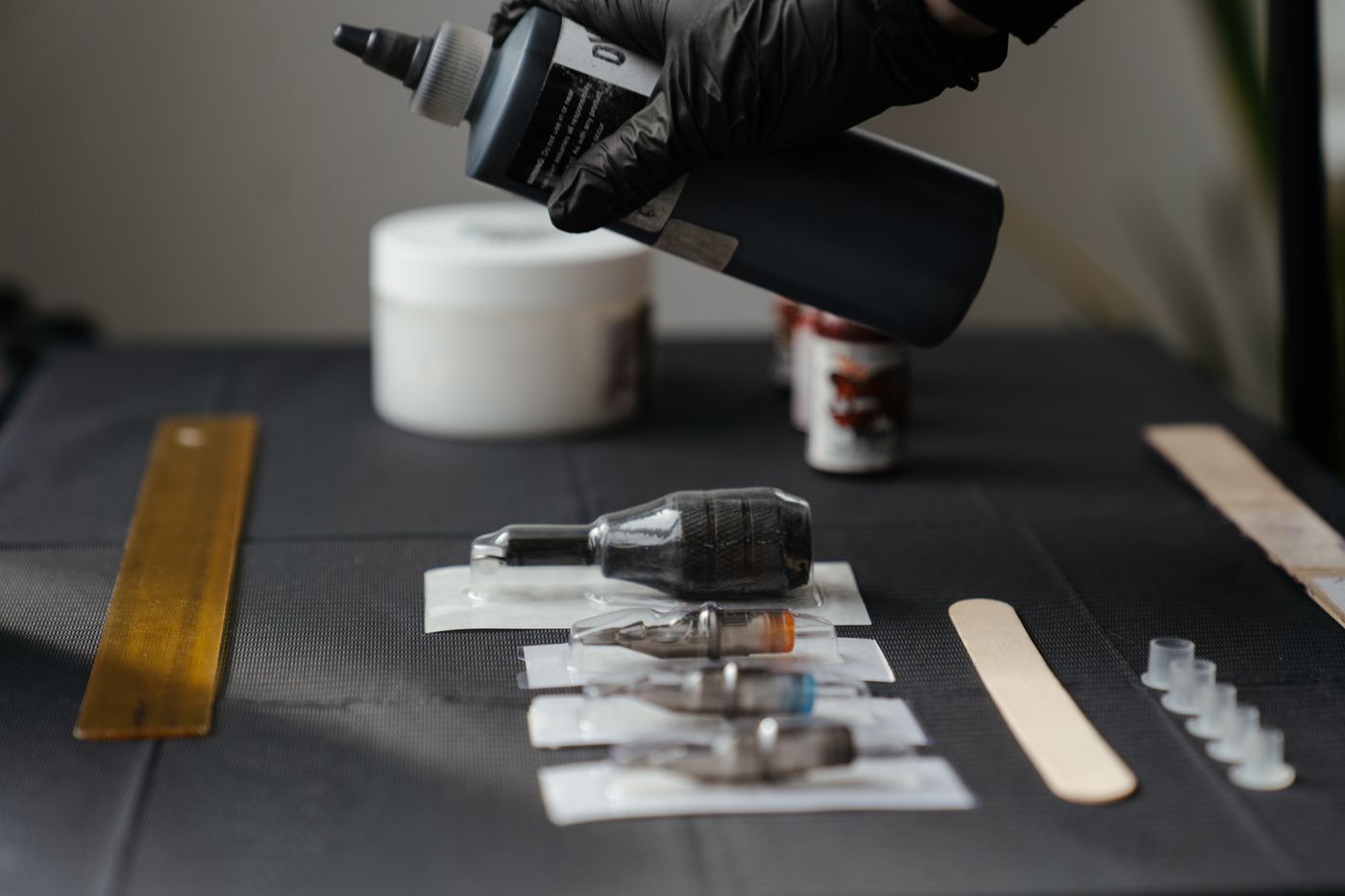 Tattoo machine and wrapped tools on a dark surface