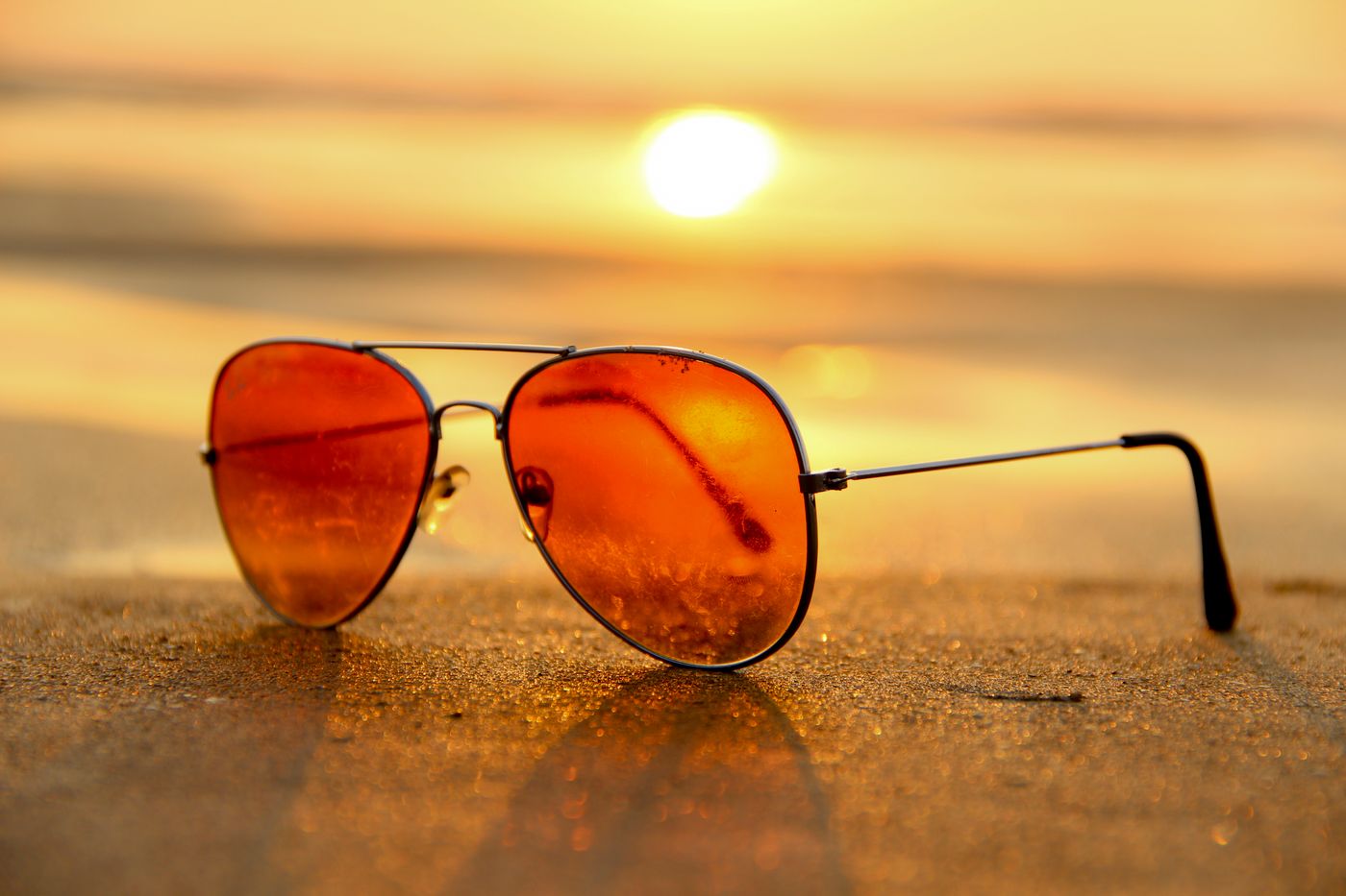 Amber-tinted aviator sunglasses on a warm surface
