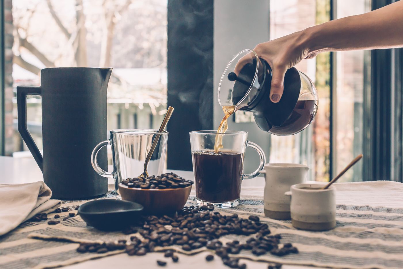 Coffee being poured from a press into a glass