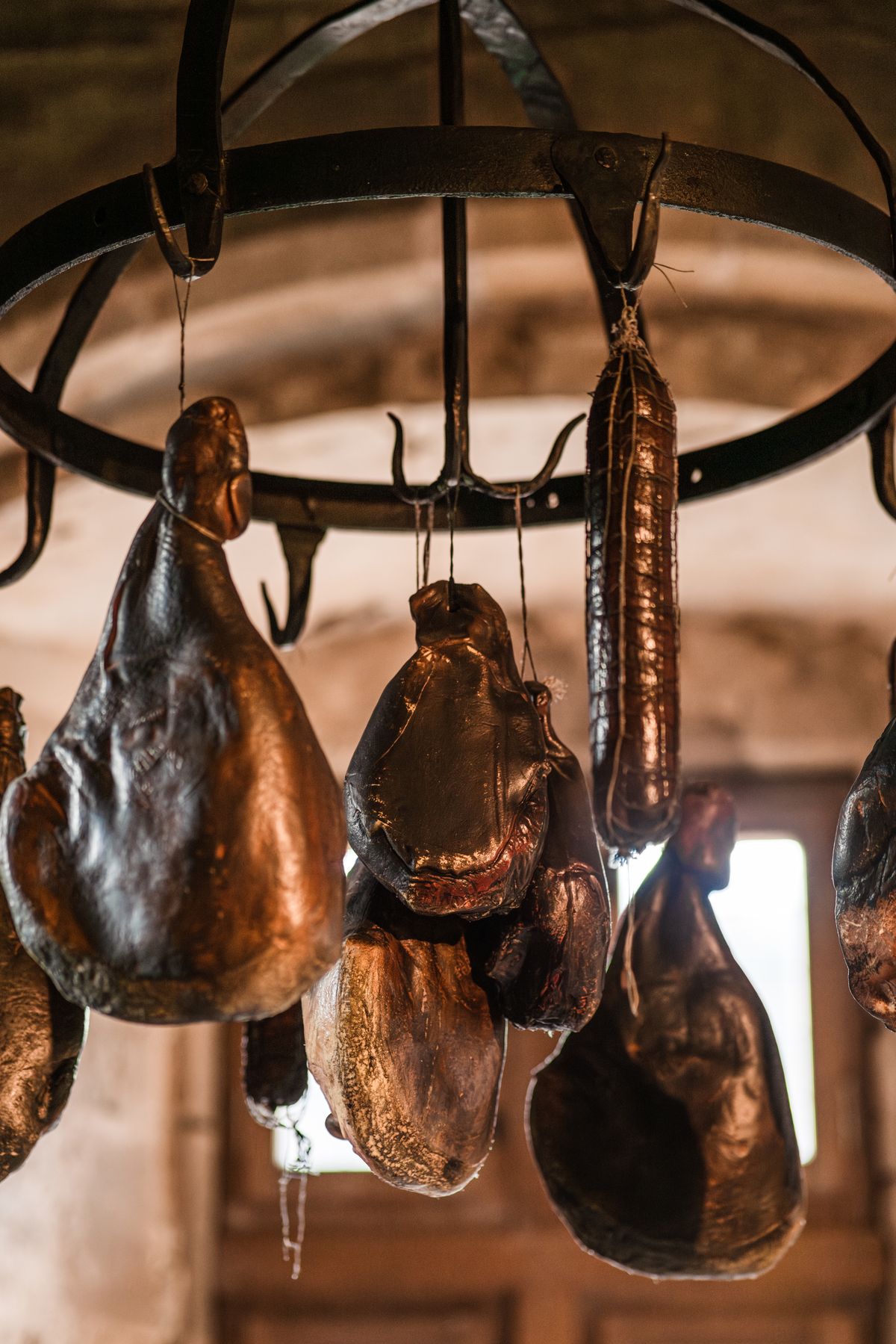 Cured meats hanging above imported pantry shelves