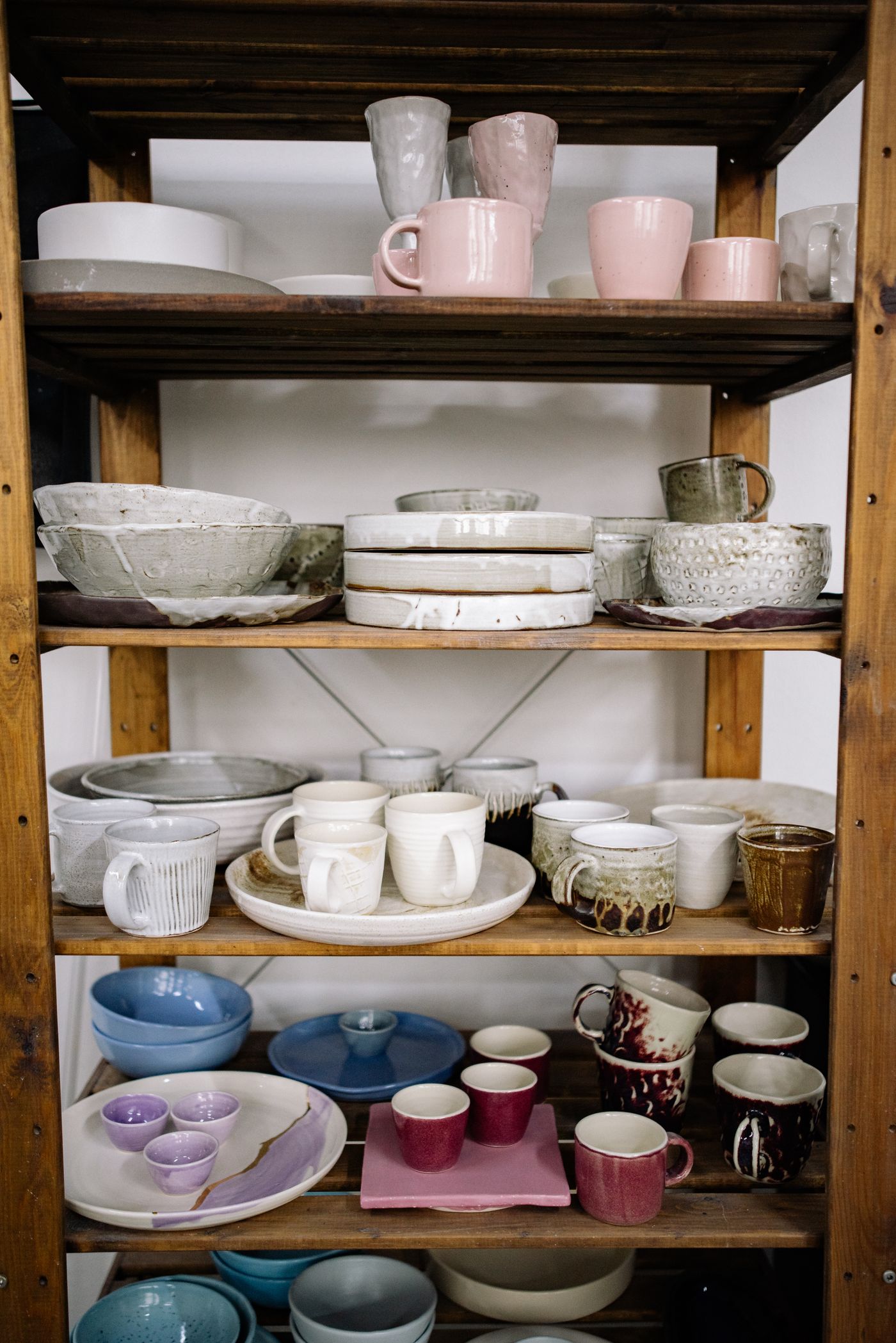 Studio shelves of finished ceramic bowls and plates