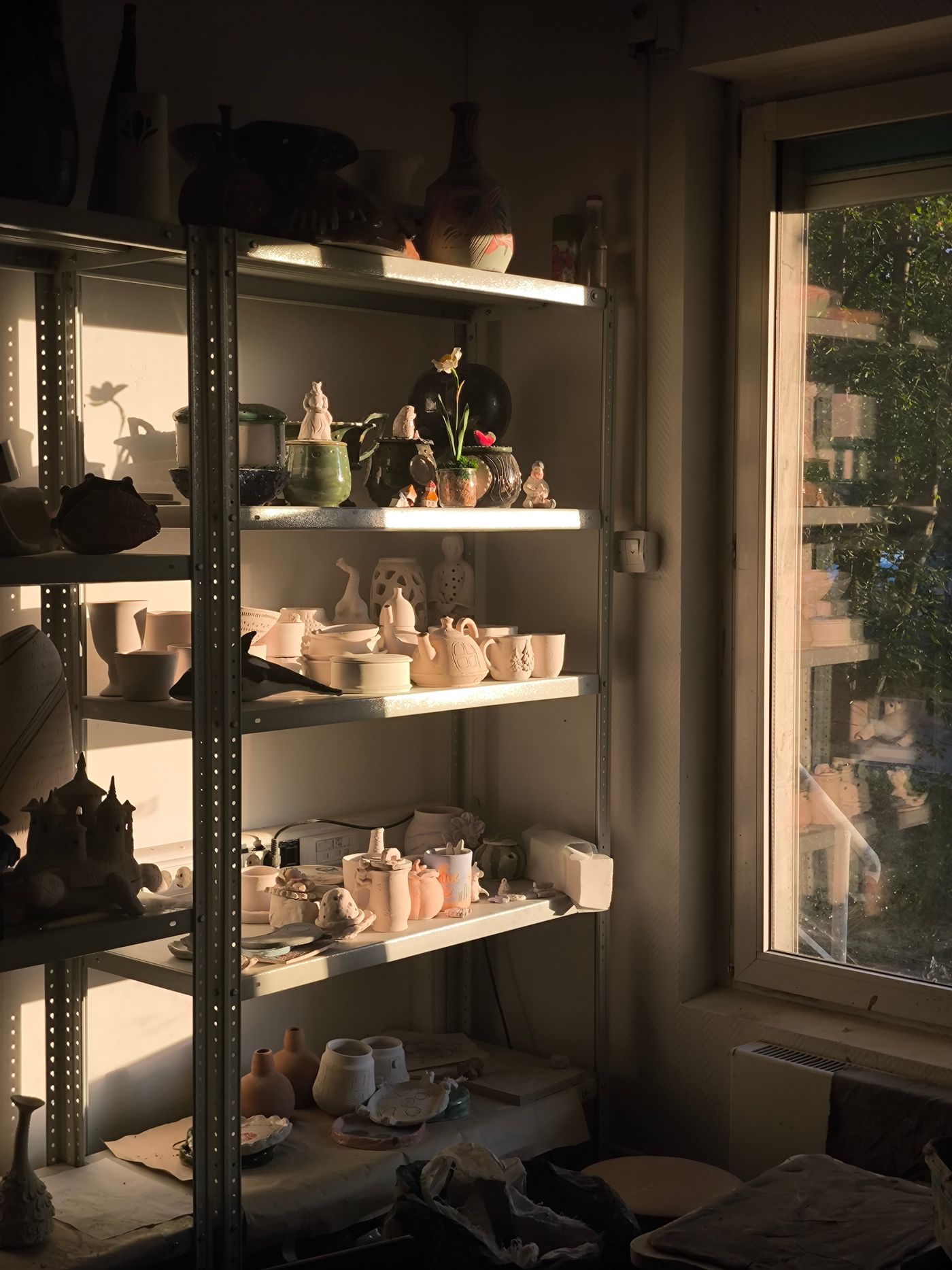 Sunlit ceramics studio with shelves of pieces