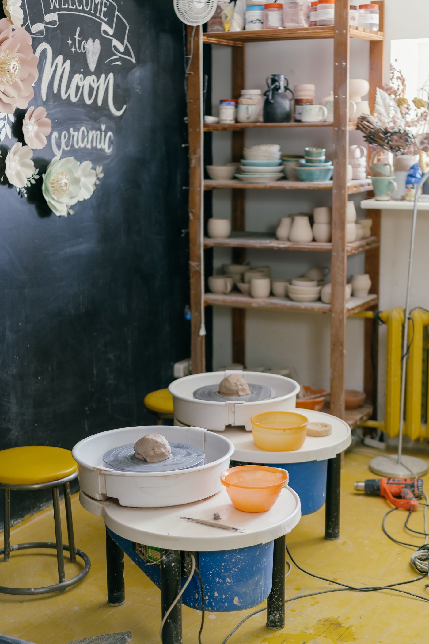 A ceramics studio with pottery wheels and shelves of pieces