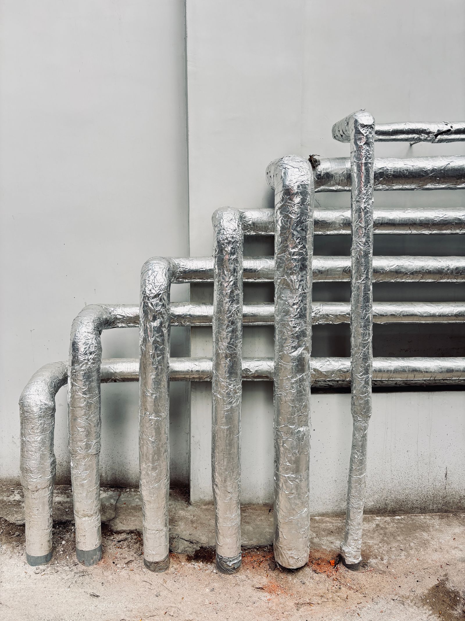 Insulated heating lines against a wall