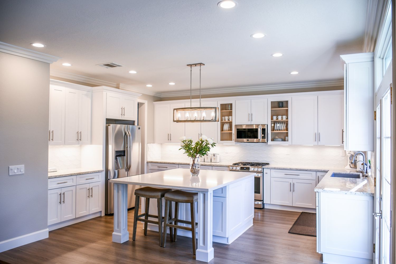 Detail of renovated kitchen cabinetry, island and stone countertop
