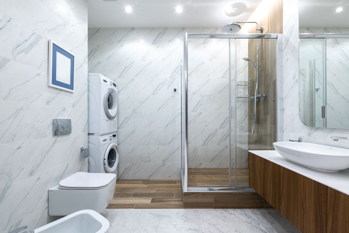 Marble bathroom with glass shower and laundry plumbing