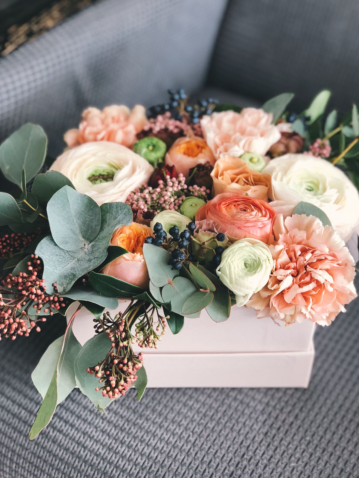 A seasonal box arrangement of peach, cream and blush blooms