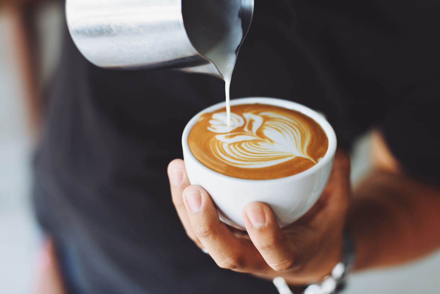 Hands pouring latte art