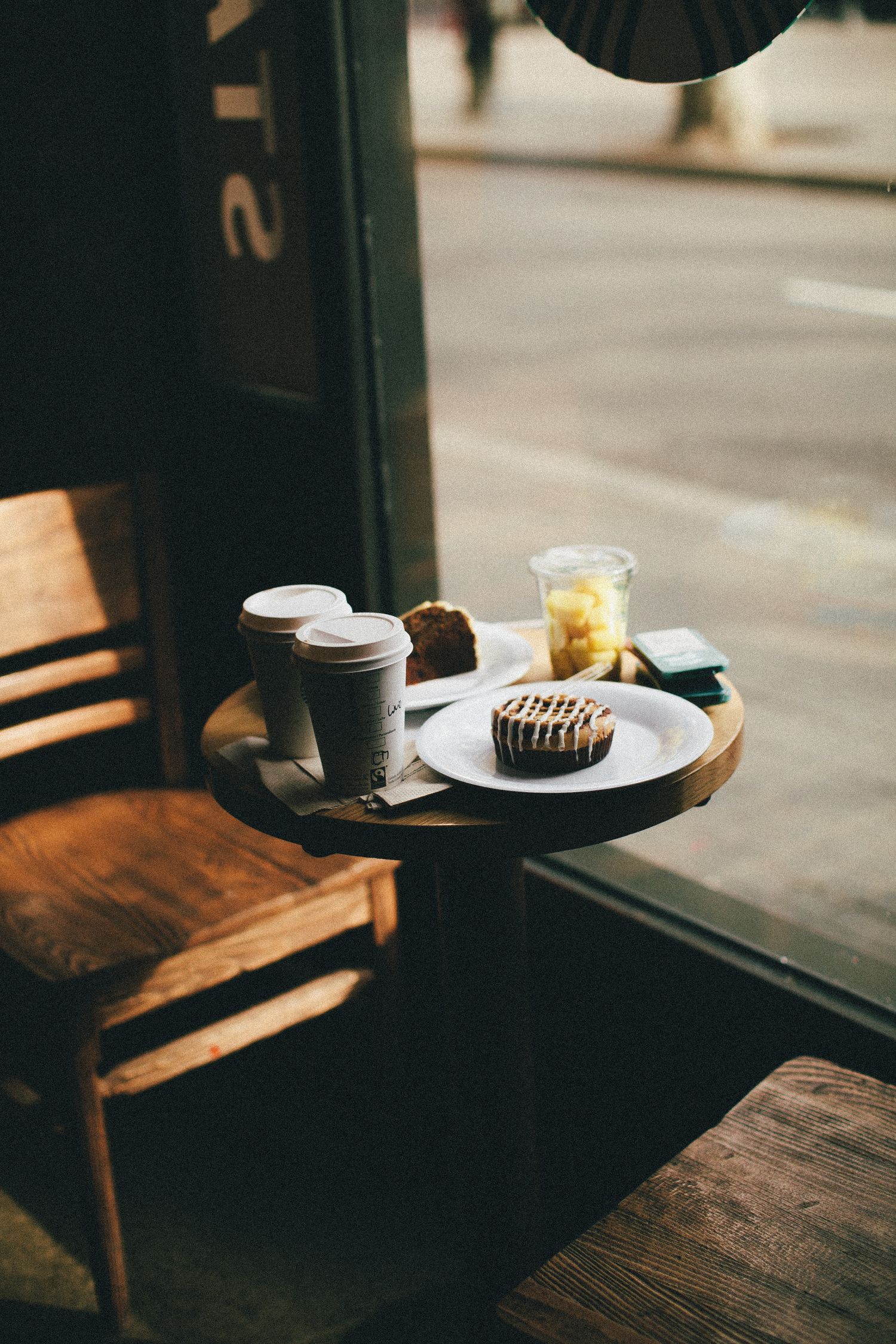 A coffee and pastry on a window-seat table