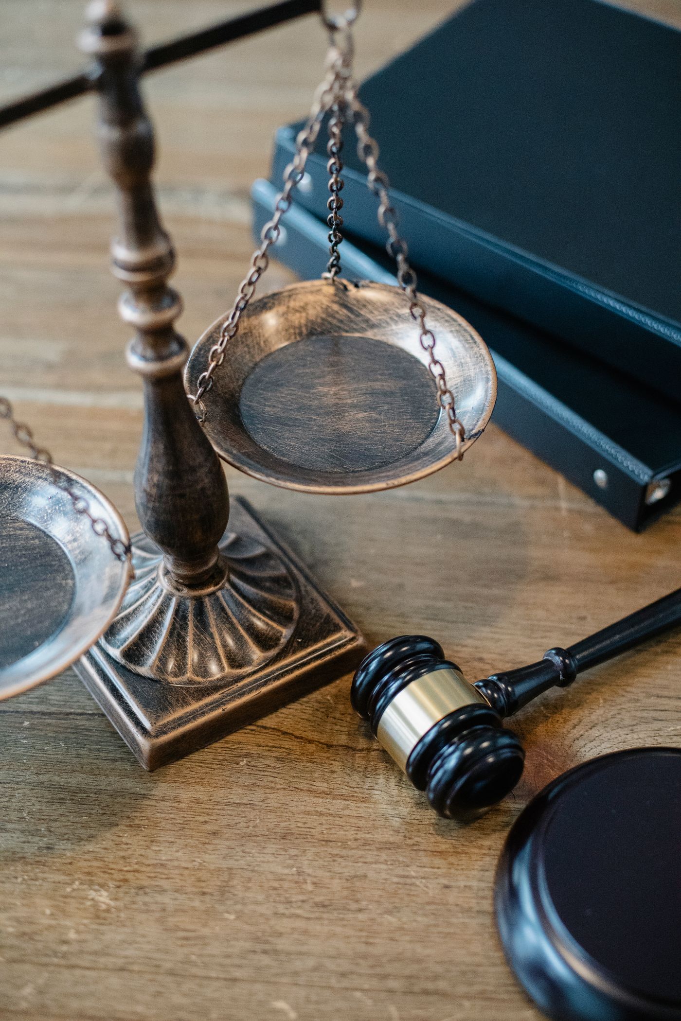 Brass scales of justice and a gavel beside law books