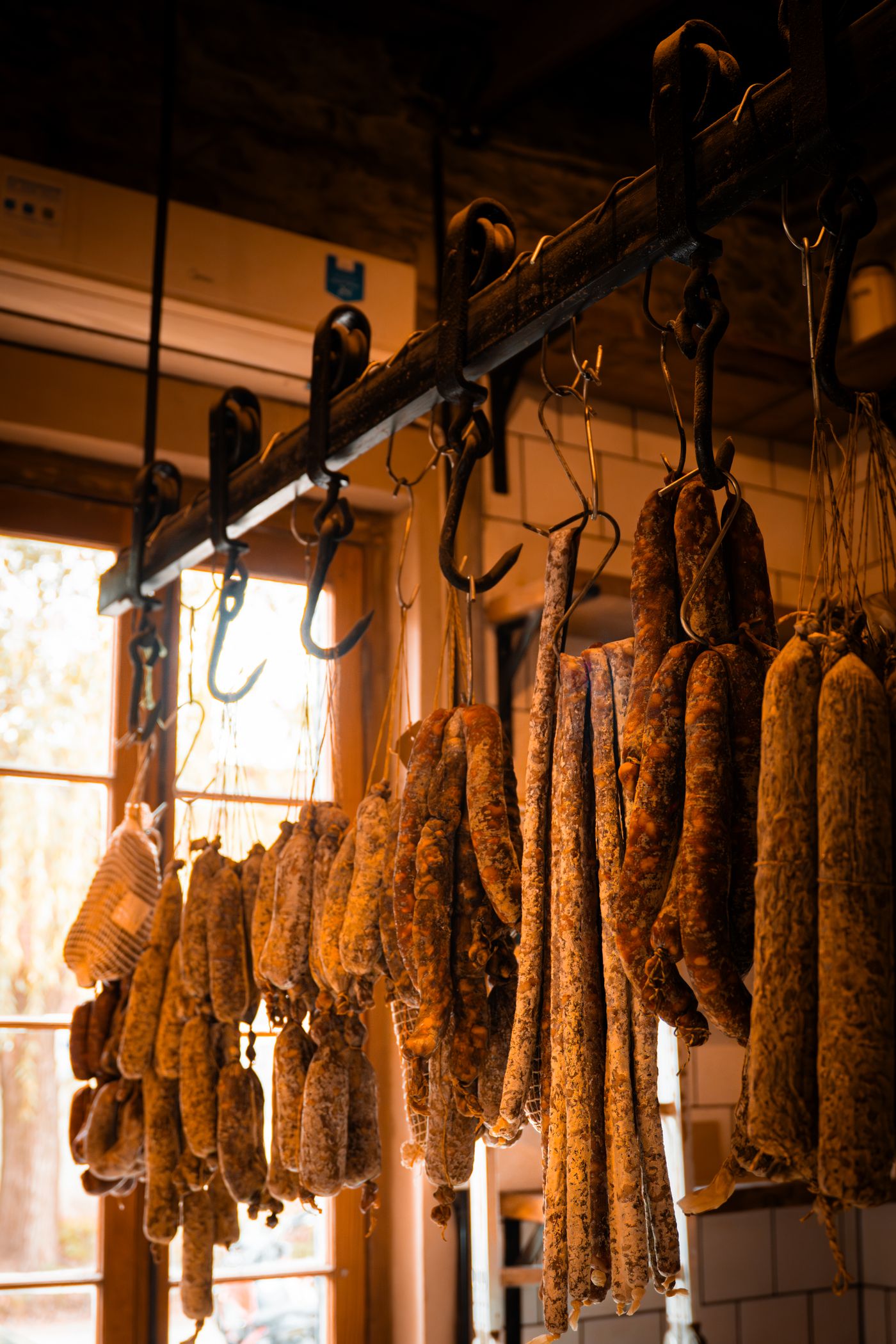 House-cured sausages hanging in the smokehouse