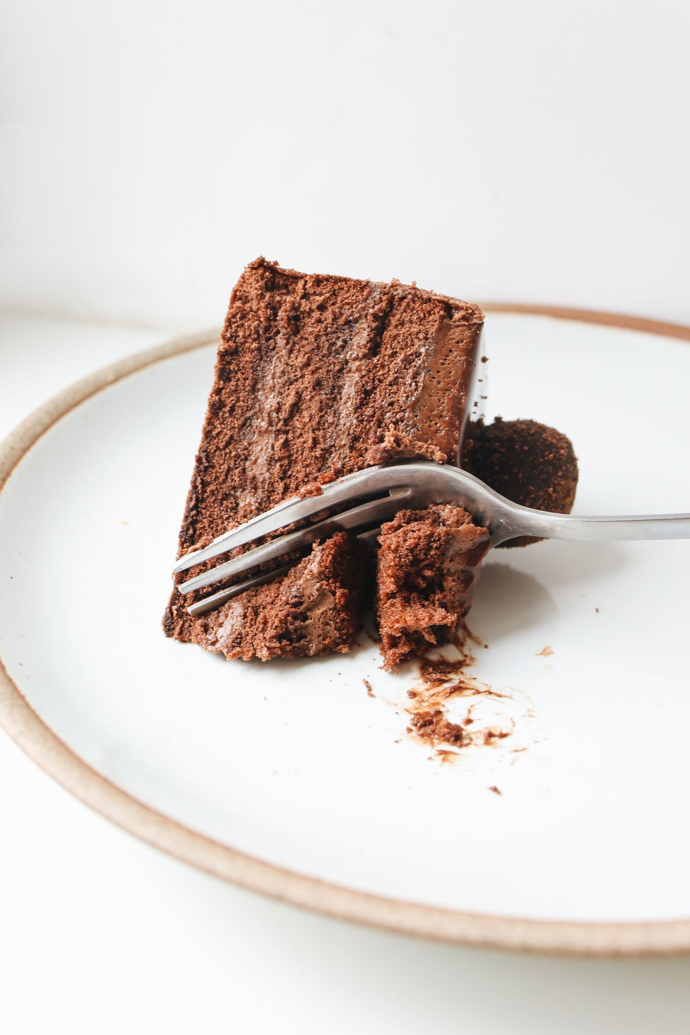 A slice of layered chocolate cake on a fork