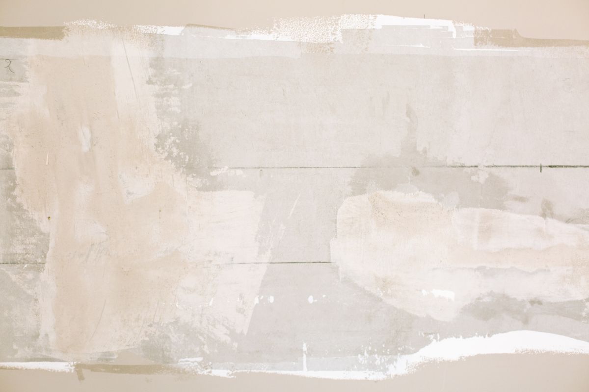 Close-up of fresh plaster and paint on a repaired wall — a material sample