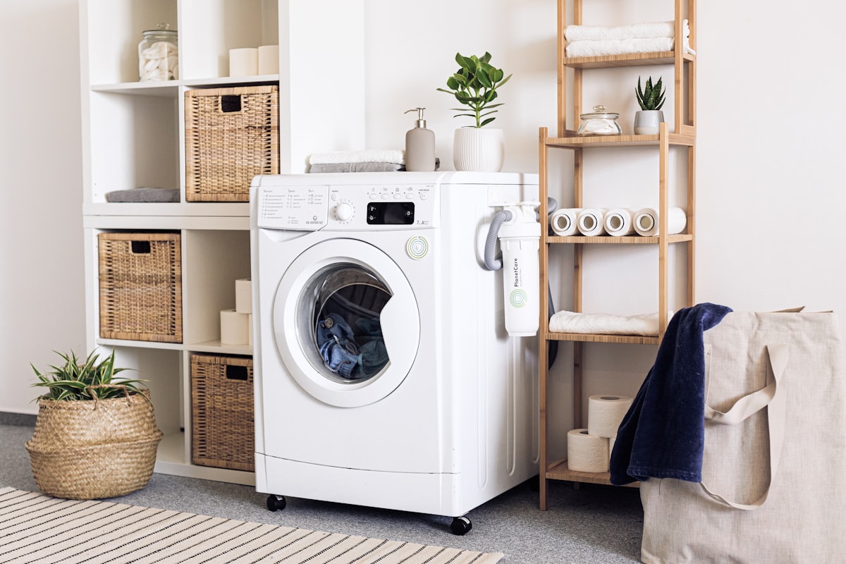 A front-load washing machine in a tidy laundry room