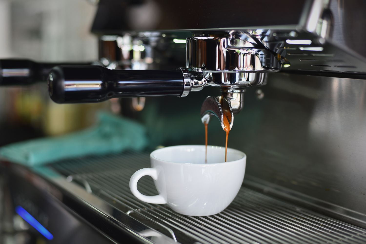 An espresso machine and a white cup