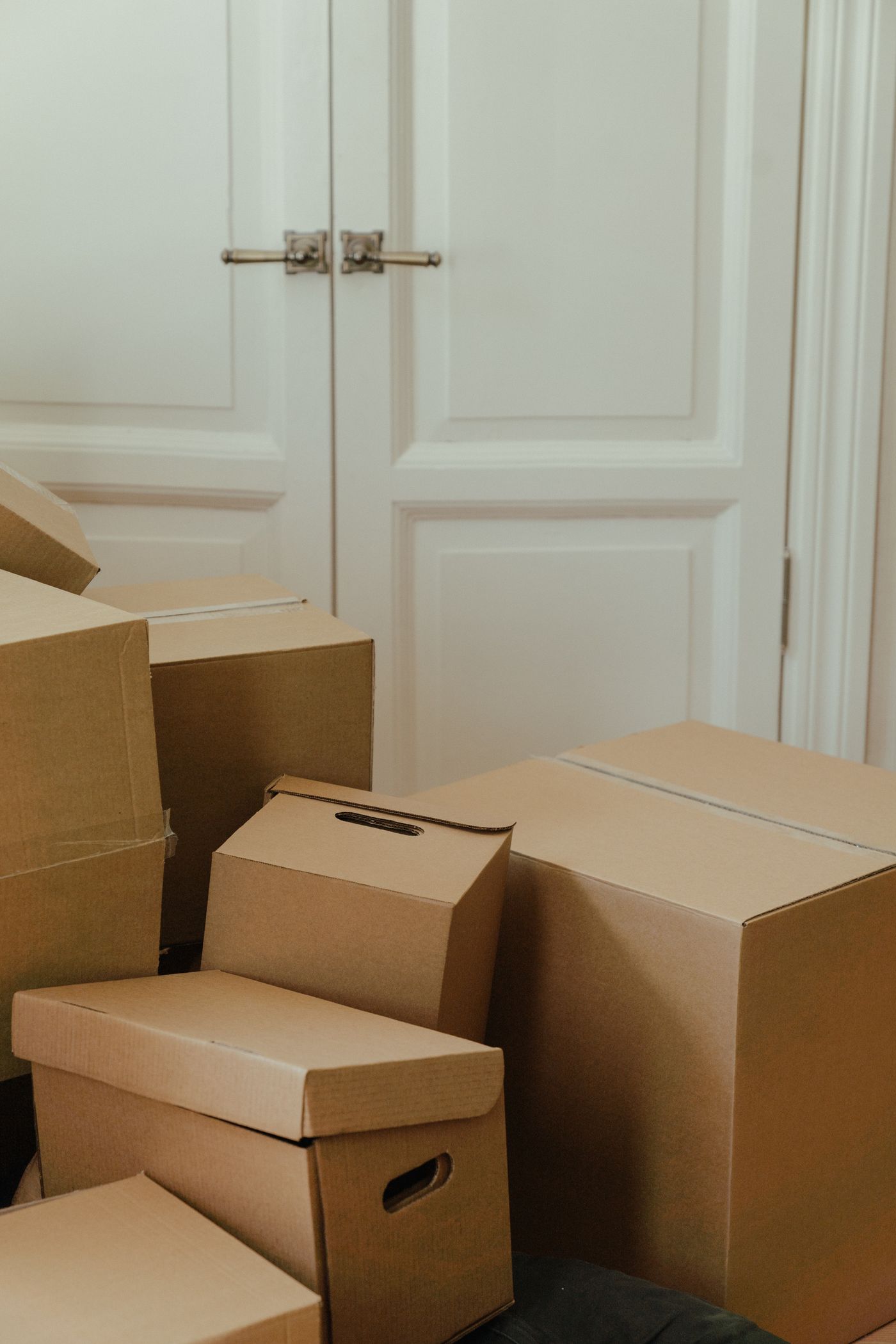 Cardboard boxes stacked by a doorway, ready to carry