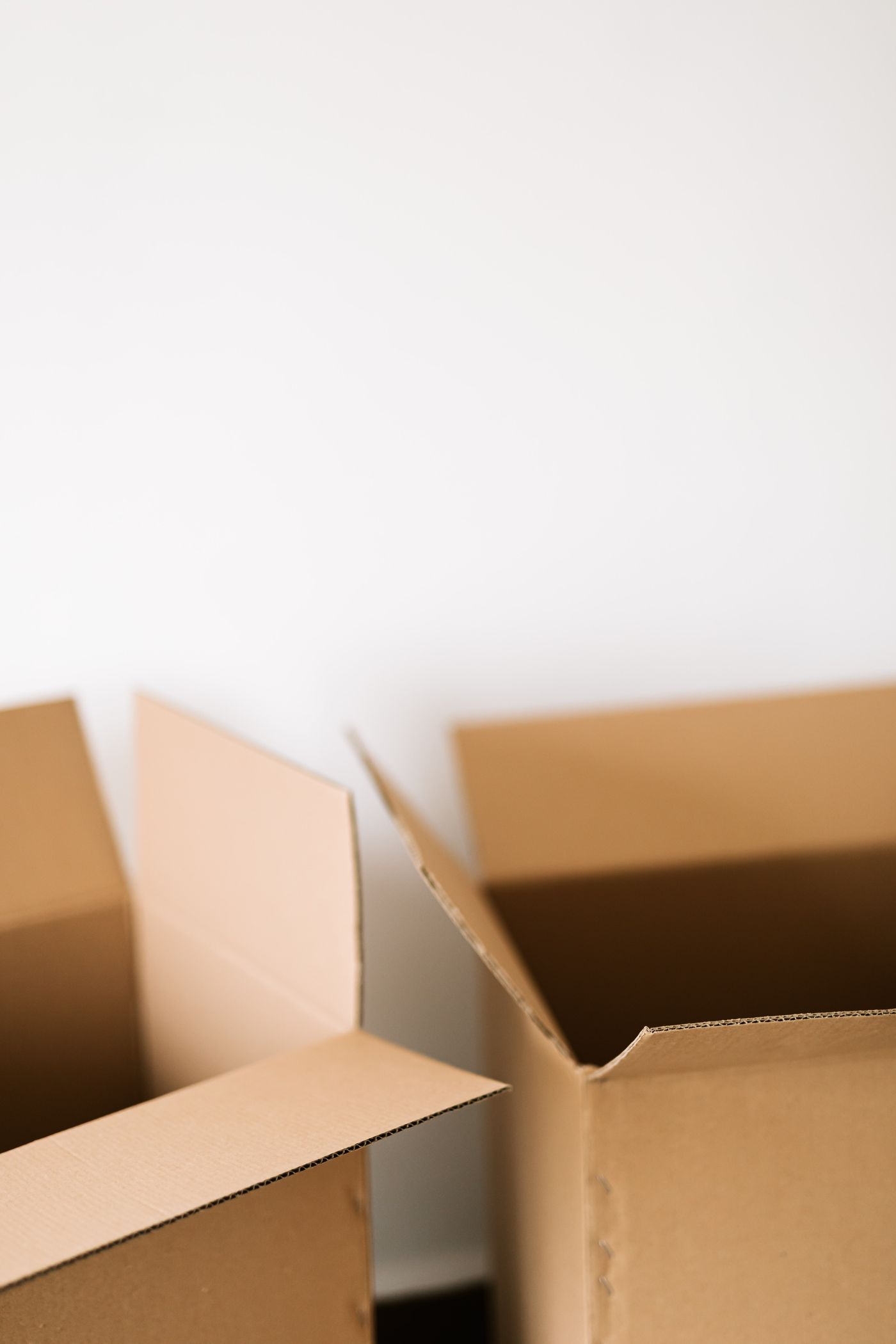 Open cardboard boxes against a white wall
