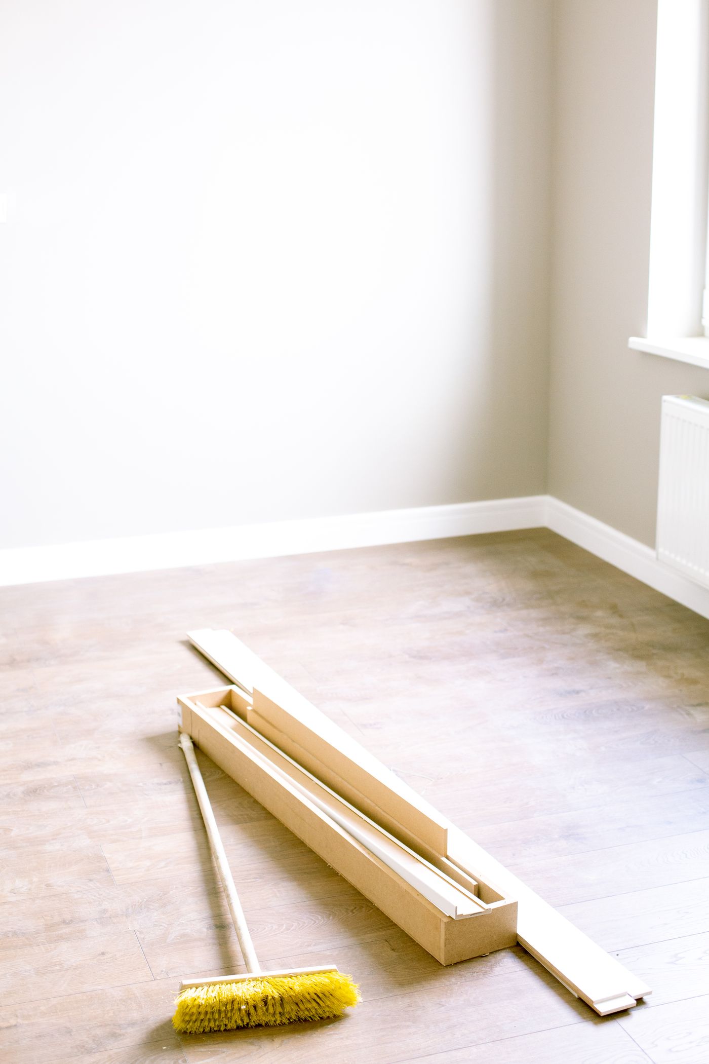 An empty room with a broom after a move-out