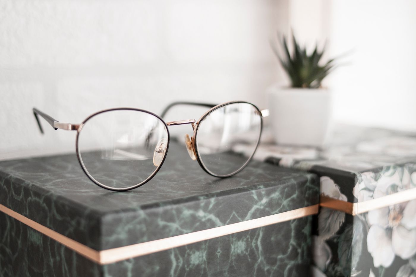 Round wire designer frames displayed on green marble