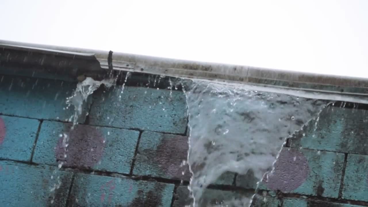 Rain pouring off the edge of a roofline