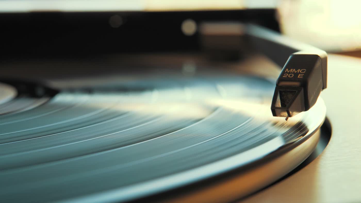 A vinyl record spinning on a turntable as the needle drops