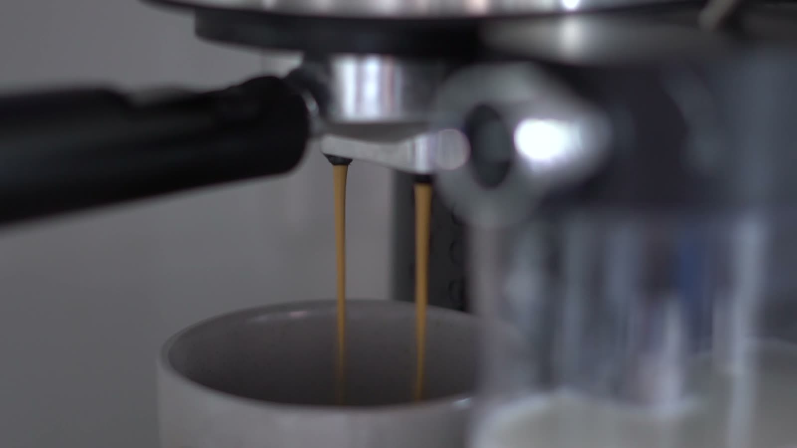 Espresso brewing into a cup with steam