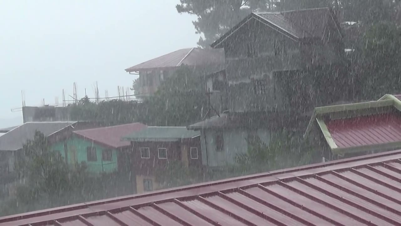 Heavy rain falling over neighbourhood rooftops