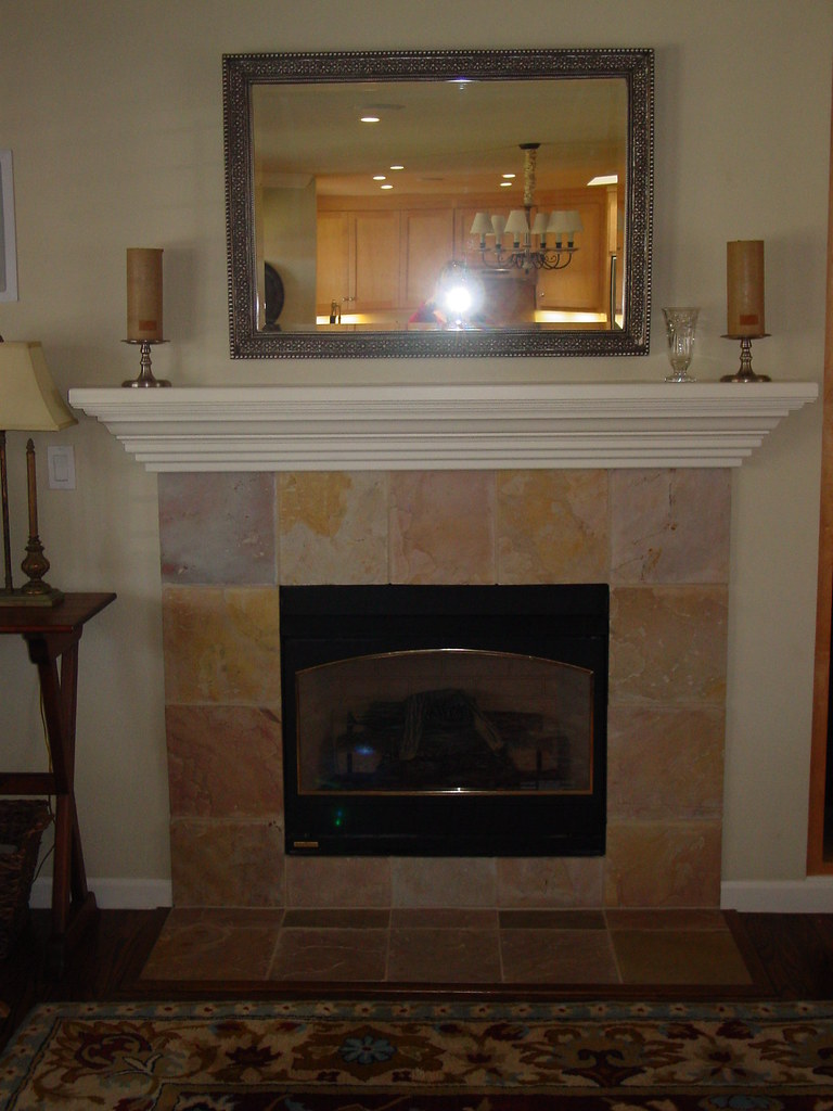 An installed gas fireplace with a stone surround