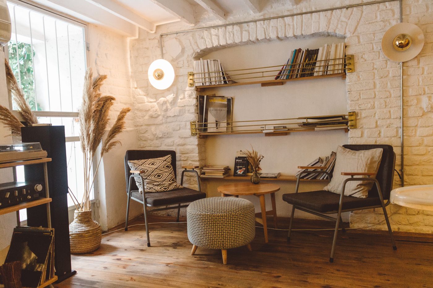 A cosy reading nook with stacked books and an armchair