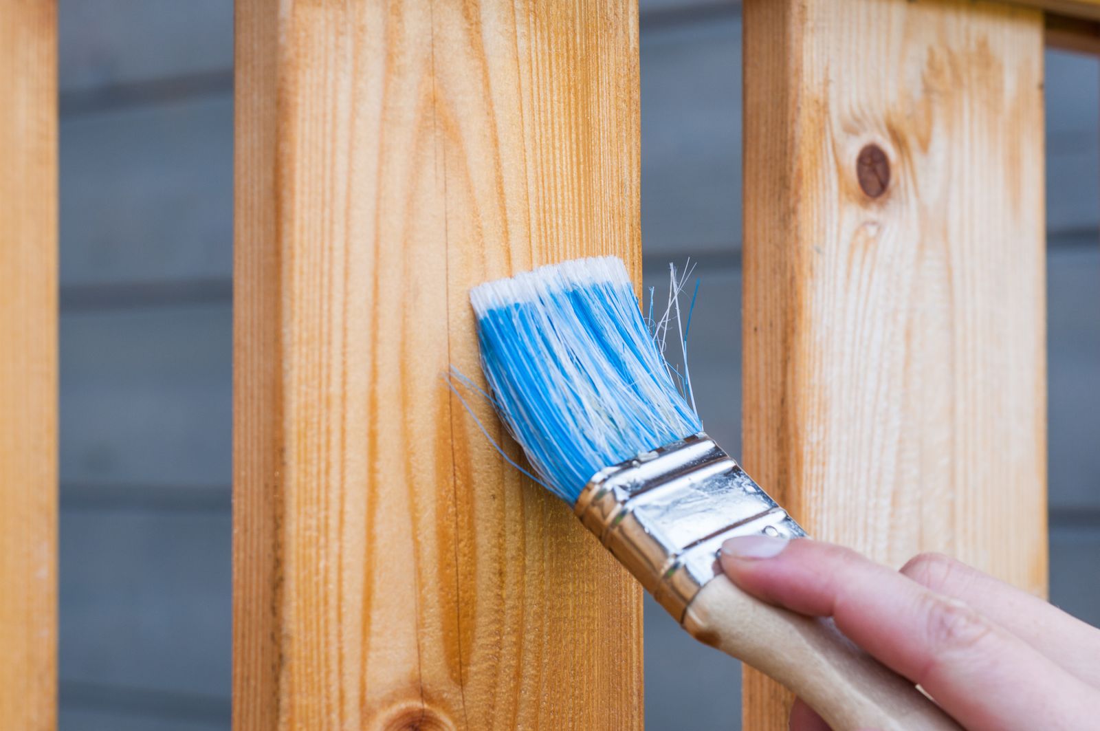 A brush laying fresh paint on wood trim