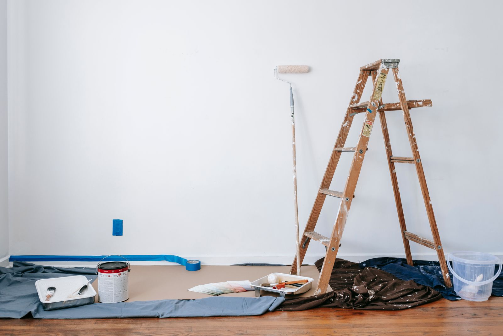 Ladder and drop cloth set up in a room being painted
