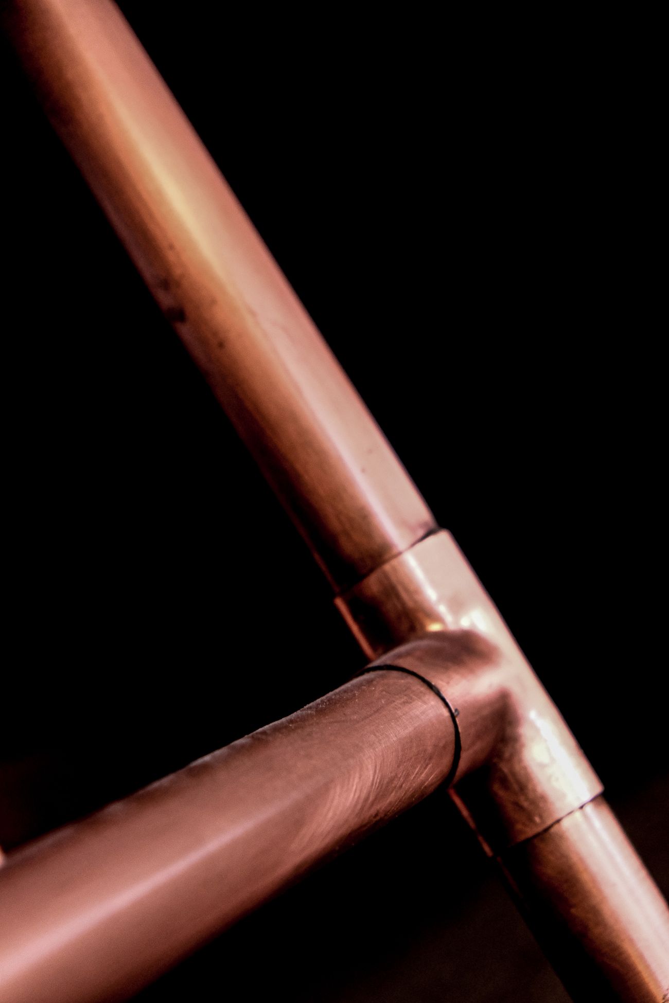 Copper pipework against a dark background
